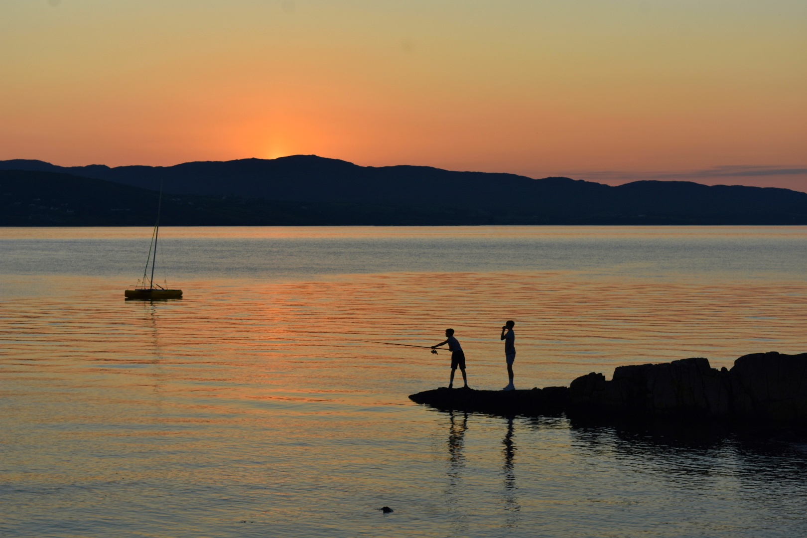 Sunset over the water with fishermen